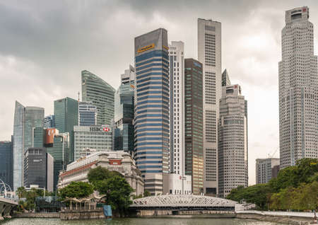 Singapore - March 20, 2019: White Anderson Bridge and a few towers of financial district under heavy cloudscape. Some green foliage on both sides.のeditorial素材