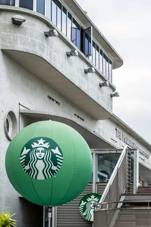 Singapore - March 20, 2019: Large green balloon with Starbucks logo at the gray building called The Fullerton Waterboat House. against silver sky.のeditorial素材
