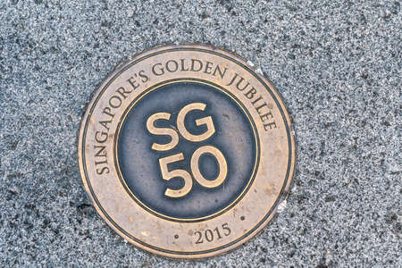 Singapore - March 20, 2019: Circular medallion for Golden Jubilee of Singapore Independence set in sidewalk.のeditorial素材
