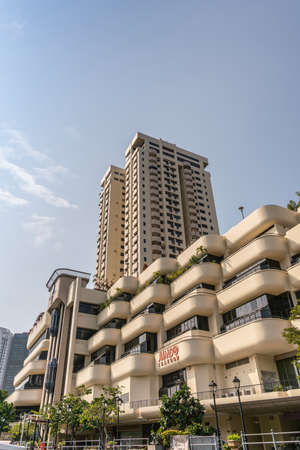 Singapore - March 21, 2019: Along Singapore River. The Riverwalk apartment complex with tower under blue sky houses Jumbo Seafood restaurant. Green foliage.のeditorial素材