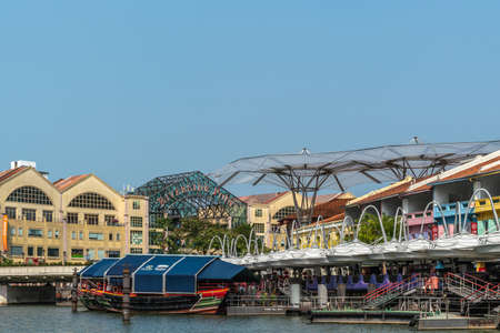Singapore - March 21, 2019: Closeup of Boats on Singapore River at North Boat Quay with its colorful houses, now bars and restaurants under blue sky.のeditorial素材