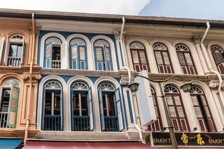 Singapore - March 22, 2019: Chinatown. Closeup of painted facades in Sago Street shows different colors, open and closed window with wooden shutters.のeditorial素材