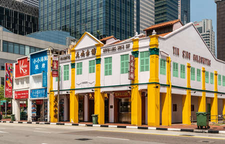 Singapore - March 22, 2019: Chinatown. Yin Sing Goldsmiths and Jewellers on South Bridge Road is large white and yellow corner building. Skyscrapers behind, and other retailers as neighbors.のeditorial素材