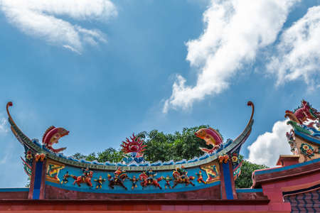 Manila, Philippines - March 5, 2019: Chinese Cemetery in Santa Cruz part of town. Closeup of colorful fishes decoration of roof at temple and ceremonial hall, under blue sky.のeditorial素材