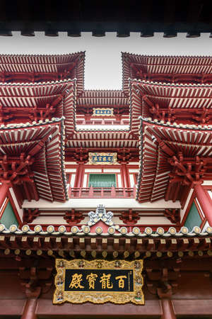 Singapore - March 22, 2019: Chinatown. Portrait, Fish eye view on pagoda-like structure of main entrance maroon-red facade of Buddha Tooth Relic Temple.のeditorial素材