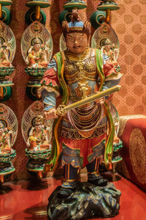 Singapore - March 22, 2019: Buddha Tooth Relic Temple in Chinatown. Virudhaka statue, One of Heavanly Kings, protecting the South with his sword. Colorfully painted sculpture.のeditorial素材