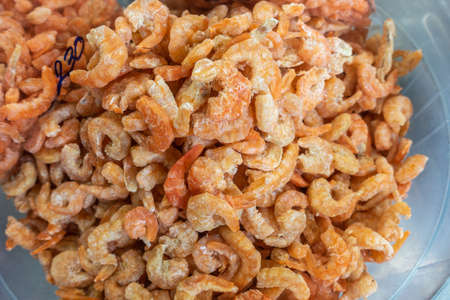 Chon Buri, Thailand - March 16, 2019: Closeup of heap of dried small orange-yellow shrimp on display at street market in Sukhumvit Road.の写真素材