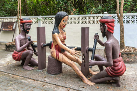 Bang Saen, Thailand - March 16, 2019: Garden of Hell in Wang Saensuk Buddhist Monastery. Scene wherein two devils kill woman by screwing two giant vises into her abdomen and back.の写真素材