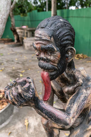 Bang Saen, Thailand - March 16, 2019: Garden of Hell in Wang Saensuk Buddhist Monastery. Scene wherein man with a longue red tonque begs for mercy. closeup of his face.の写真素材