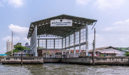 Bangkok city, Thailand - March 17, 2019: Bangkok Noi Canal. Tall covered loading dock without boats under blue cloudscape. Light gray dominant color.のeditorial素材