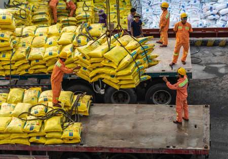 Da Nang, Vietnam - March 10, 2019: Tien Sa Port in Da Nang Bay. Closeup of men in orange garb...