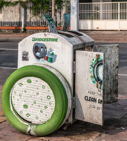 Da Nang, Vietnam - March 10, 2019: Light gray filthy trashcan sponsored by Bridgestone tires and with open doors wants to project environmental awareness along boardwalk of Han River.のeditorial素材