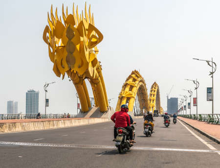 Da Nang, Vietnam - March 10, 2019: Together with traffic, Entering from west over Han River on Cau Rong or Dragon bridge under morning sky. Some high rise buildings on other side.のeditorial素材