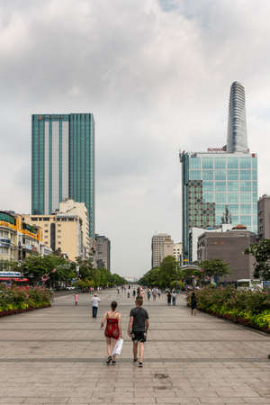 Ho Chi Minh City, Vietnam - March 12, 2019: Downtown. Broad Nguyen Hue boulevard, parade grounds and pedestrial walkway leading to southeast to Song Sai Gon River. Office buildings and people.のeditorial素材