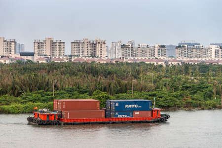 Ho Chi Minh City, Vietnam - March 12, 2019: Closekup of small red container barge on Song Sai Gon...