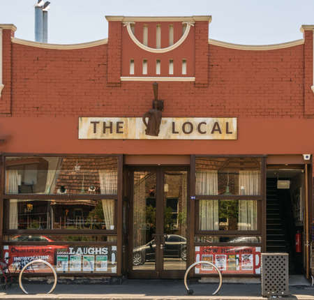 Melbourne, Australia - December 17, 2009: The Local Taphouse on corner of Carlisle and Chapel streets. Red stone front facade with windows reflecting street traffic. 3-dimensional logo of mug and tap.のeditorial素材