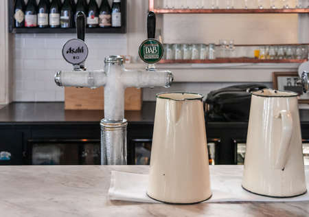 Melbourne, Australia - December 17, 2009: European Cafe on corner of Exhibition and Collins. Closeup of 2 pitcher cans and an iced 2-handle tap installation pouring Asahi and Dortmunder DAB.のeditorial素材