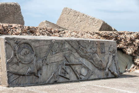 Newcastle, Australia - December 10, 2009: Peaceful scenery on boar of ship with resting sailors and sailing tools artwork edged on defensive large gray stone on Nobbys breakwater pier.のeditorial素材