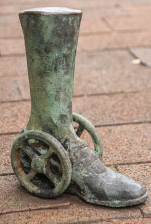 Newcastle, Australia - December 10, 2009: Closeup of Greenish bronze statue of leg with shoe on wheels on brown stones of Hunter shopping street.のeditorial素材