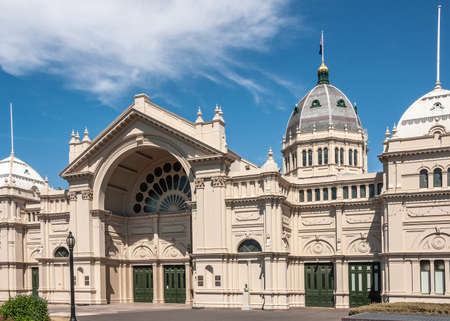 Melbourne, Australia - November 18, 2009: Dome in back and exquisite architecture of gray-beige stone wings and halls of Royal Exhibition Building under blue sky.のeditorial素材