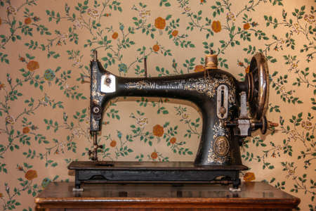 Stanley, Tasmania, Australia - December 15, 2009: Hightfield Historic Site. Antique Wertheim sewing machine on brown cabinet in front of vintage wall paper.のeditorial素材
