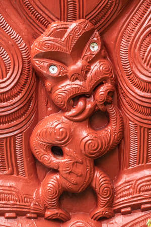 Laie, Oahu, Hawaii, USA. - January 09, 2020: Polynesian Cultural Center. Closeup of detail of red wooden sculpture showing small scary figure at New Zealand Maori hawaikiroa hall.のeditorial素材