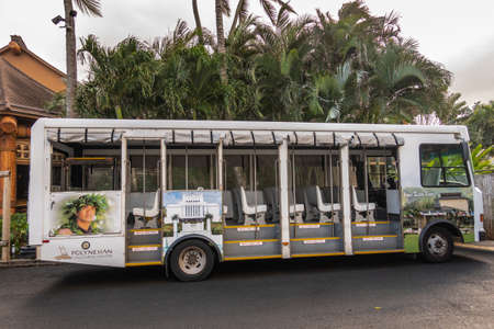 Laie, Oahu, Hawaii, USA. - January 09, 2020: Polynesian Cultural Center. White open public transport bus used inside the park with photo of young male polynesian man. Back is green palm trees.のeditorial素材