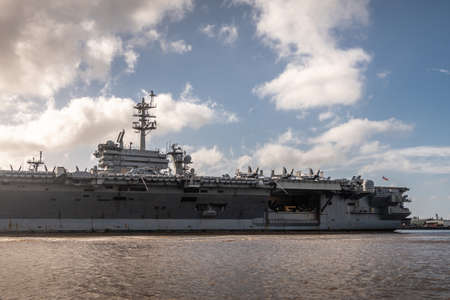 Oahu, Hawaii, USA. - January 10, 2020: Pearl Harbor. Stern part of Port side of Gray Abraham Lincoln aircraft carrier docked under blue cloudscape on top of brown water.のeditorial素材