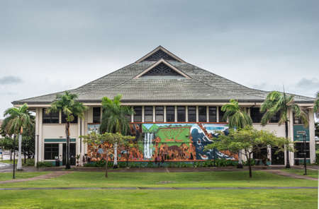 Kahului, Maui,, Hawaii, USA. - January 12, 2020: Big hall or Kaaike behind green lawn and under light blue sky at University of Hawaii, Maui college campus. Big wall painting featuring brown aboriginals.のeditorial素材
