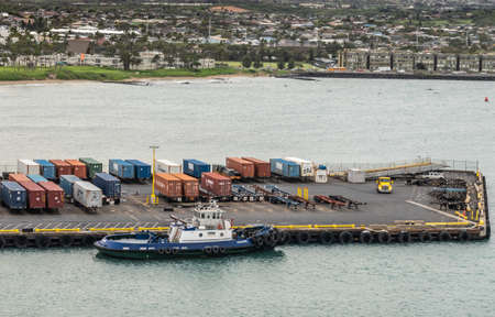 Kahului, Maui,, Hawaii, USA. - January 13, 2020: Kalamag, a young bros tugboat docked at pier with shipping containers on trailers. Cityscape in back.のeditorial素材