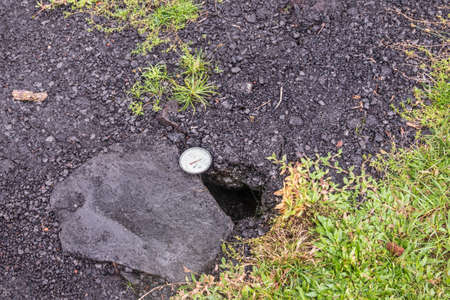 Leilani Estate, Hawaii, USA. - January 14, 2020: Devastation in parts untouched by 2018 lava. Dial placed in crack of road to measure temperature. Placed by government security forces.の写真素材