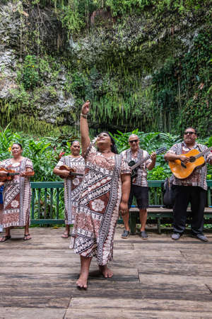 Kamokila Village, Kauai, Hawaii, USA. - January 16, 2020: Local folk band performs on stage in front of Fern Grotto. Female singer in front. Green background.のeditorial素材