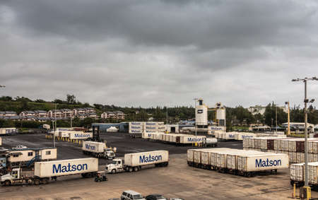 Nawiliwili, Kauai, Hawaii, USA. - January 17, 2020: Matson shipping container yard with plenty loaded trailers under gray rainy cloudscape.のeditorial素材