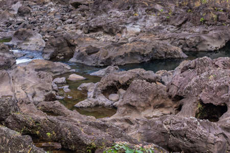 Hilo, Hawaii, USA. - January 9, 2012: Brown rock river bed above Rainbow falls show only a bit of water.の写真素材