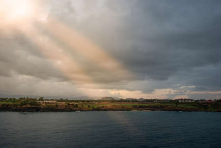 Nawiliwili, Kauai, Hawaii, USA. - January 11, 2012: Early morning light on Timbers Kauai Ocean Golf Club and Residences under dark clooudscape with yellow spot and two sun rays.のeditorial素材