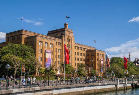 Sydney, Australia - December 11, 2009: Brown stone historic building of Museum of Contemporary Art under blue sky at Circular Quay with people and green foliage.のeditorial素材