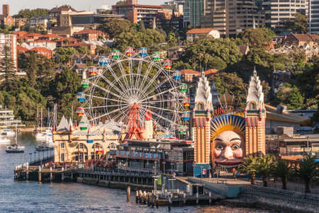 Sydney, Australia - December 11, 2009: Closeup of colorful Luna Park fair attractions with Kirribilli builidngs in back. Some green foliage.のeditorial素材