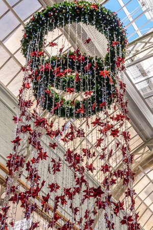 Sydney, Australia - December 11, 2009: Closeup of green Christmas wreath hanging from ceiling of Queen Victoria shopping mall with plenty of red stars and blue sky patch.のeditorial素材