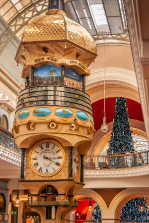 Sydney, Australia - December 11, 2009: Decorative beige-brown clock tower with multicolor scenery pictures of people and of islands inside Queen Victoria building shopping mall.のeditorial素材