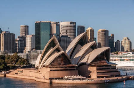 Sydney, Australia - December 11, 2009: Opera House. Closeup with business skyscrapers in back under blue sky.のeditorial素材