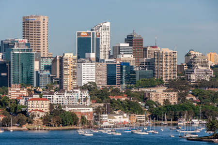 Sydney, Australia - December 11, 2009: North Sydney cityscape with office towers of businesses behind Neutral Harbour and its anchored white yachts. Lots of houses and green foliage.のeditorial素材