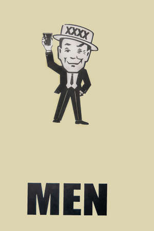 Brisbane, Australia - December 8, 2009: Castlemaine Perkins brewery. Black on yellow sign on door of toilet for men.のeditorial素材