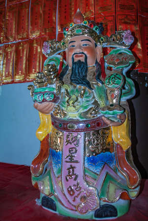 Guilin, China - May 11, 2010: Qixia Buddhist Temple in Seven Star Park. Frontal view on colorful statue of king bringing gifts to the Buddha.のeditorial素材