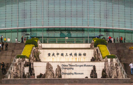 Chongqing, China - May 9, 2010: Downtown.  Landscape Closeup of green glass Three Gorges Museum building entrance. Plenty of people.のeditorial素材