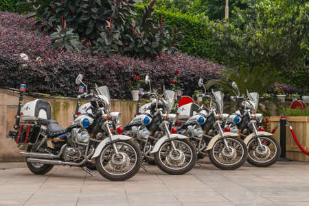 Chongqing, China - May 9, 2010: Downtown. Closeup of 4 parked identical Police motorcycles with red...