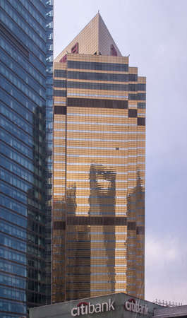 Shanghai, Pudong, Lujiazui, China - May 4, 2010: Shadow of World Financial Center and Jin Mao skyscraper reflected on golden glass facade of other. Citibank logo at bottom.のeditorial素材