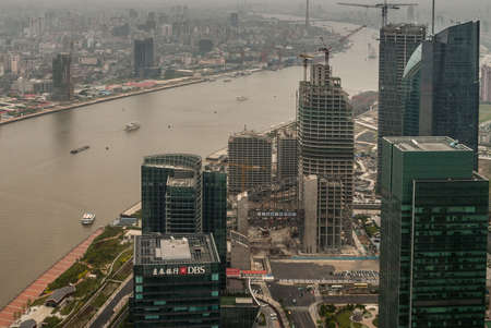 Shanghai, Pudong, Lujiazui, China - May 4, 2010: DBS and other highrise buildings, some under construction with Huangpu brown water river. More buildings on other shore.のeditorial素材
