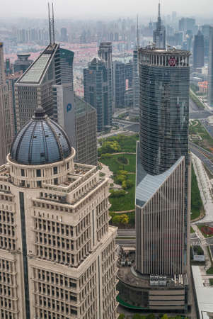 Shanghai, Pudong, Lujiazui, China - May 4, 2010: Closeup of beige with dome China Ping An Finance building and green glass Bank of China tower on the side. Smog covers horizon.のeditorial素材