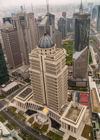 Shanghai, Pudong, Lujiazui, China - May 4, 2010: Closeup of beige with dome China Ping An Finance building and green glass Bank of China tower on the side. Smog covers horizon.のeditorial素材