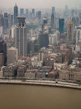 Shanghai, China - May 4, 2010: Aerial view on historic section of The Bund behind brown Huangpu River and sea of highrise buildings under smog as backdrop.のeditorial素材
